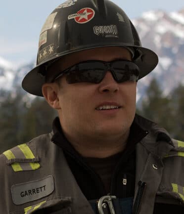Garrett Radchenko profile picture with hardhat and coveralls
